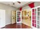 Home office featuring a built-in bookshelf and French doors leading to the dining room at 10757 Carloway Hills Dr, Wimauma, FL 33598