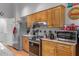 Functional kitchen featuring tile backsplash, stainless steel appliances and wooden cabinetry at 11121 Sun Tree Rd, Hudson, FL 34667