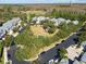 Aerial view of a neighborhood featuring manicured lawns and lush landscaping around homes and common play area at 11132 Roseate Dr, Tampa, FL 33626