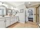 Well-lit bathroom with dual vanities, framed mirrors, and walk-in shower at 11132 Roseate Dr, Tampa, FL 33626