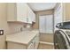 Bright laundry room with a sink, ample counter space, storage cabinets, and a modern washer and dryer at 11132 Roseate Dr, Tampa, FL 33626