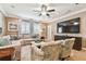 Comfortable living room with neutral tones, a large sectional sofa, and a ceiling fan at 11132 Roseate Dr, Tampa, FL 33626