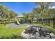 Playground with a slide, picnic table, and benches surrounded by manicured lawn and a wrought iron fence at 11132 Roseate Dr, Tampa, FL 33626