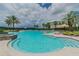 Community pool with a sunshade, lounge chairs, and palm trees, perfect for relaxing and enjoying the weather at 11132 Roseate Dr, Tampa, FL 33626