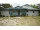 Gray house with teal accents and porch at 12217 Peaceful Ave, Weeki Wachee, FL 34614