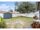 Large backyard with shed, fire pit, and partially fenced area at 1232 Calamondin Dr, Holiday, FL 34691