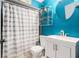 Clean bathroom with teal walls, white vanity, and striped shower curtain at 1232 Calamondin Dr, Holiday, FL 34691