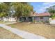 Gray house with teal door and well-maintained lawn at 1232 Calamondin Dr, Holiday, FL 34691