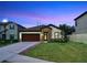 One-story home with brown garage door, stone accents, and landscaped lawn at 14610 Horse Trot Rd, Lithia, FL 33547