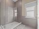 Bathroom with a walk-in shower, tile flooring, and a window for natural light at 1538 Riverside Dr, Tarpon Springs, FL 34689