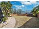 Spacious backyard with a grassy lawn, palm trees, and a paved walkway at 1621 Park N St, St Petersburg, FL 33710