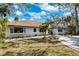 Single-story home with brown roof, white exterior, and green lawn at 1621 Park N St, St Petersburg, FL 33710