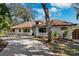 White single-story home with brown roof and lush landscaping at 1621 Park N St, St Petersburg, FL 33710