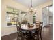 Charming dining room with a large window, chandelier, and wooden table at 16320 Rock Lake Dr, Odessa, FL 33556