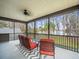 Screened porch overlooking the lake, featuring comfy seating at 16320 Rock Lake Dr, Odessa, FL 33556