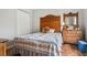 Bedroom featuring a wood-frame bed, quilt, dresser, and white closet doors at 1642 Daylily Dr, Trinity, FL 34655