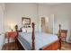 Cozy bedroom with wood floors, a wooden bed frame, a side table with a lamp, and neutral-colored walls at 1642 Daylily Dr, Trinity, FL 34655