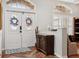 Inviting foyer featuring wood floors, an ornate door with leaded glass, and a decorative chest at 1642 Daylily Dr, Trinity, FL 34655