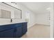 Modern bathroom with a navy blue vanity and a large mirror at 1741 Spinning Wheel Dr, Lutz, FL 33559