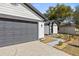 Home exterior with gray garage door and landscaped walkway at 1741 Spinning Wheel Dr, Lutz, FL 33559