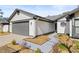 Home exterior with gray garage door and landscaped walkway at 1741 Spinning Wheel Dr, Lutz, FL 33559