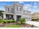 Two-story house with gray siding, three car garage, and beautifully landscaped front at 19322 Autumn Chase Ct, Land O Lakes, FL 34638