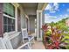 Front porch with rocking chairs and lush tropical plants at 19322 Autumn Chase Ct, Land O Lakes, FL 34638