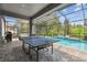 This backyard oasis features a pool, ping pong table, and covered patio at 19322 Autumn Chase Ct, Land O Lakes, FL 34638