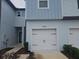 Front view of townhome, featuring a two-car garage and walkway at 19639 Shady Oak Dr, Land O Lakes, FL 34638