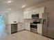 Modern kitchen with white cabinets, stainless steel appliances, and quartz countertops at 19639 Shady Oak Dr, Land O Lakes, FL 34638