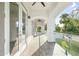 Long balcony with arched entryways, tile flooring, and glass railings at 1964 Cedar Dr, Dunedin, FL 34698