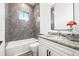 Clean bathroom, granite vanity, and grey tile shower at 1964 Cedar Dr, Dunedin, FL 34698