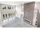 High-ceilinged living area showcasing a floor-to-ceiling fireplace and multiple sets of doors leading to the outdoors at 1964 Cedar Dr, Dunedin, FL 34698