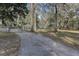 Long driveway leads through a gated entrance surrounded by mature trees at 20490 Pinewood Dairy Rd, Brooksville, FL 34601