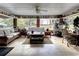 Relaxing screened porch with wicker furniture and lush greenery at 20490 Pinewood Dairy Rd, Brooksville, FL 34601