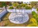 Aerial view of a paved backyard basketball court with palms around a white brick privacy fence at 2186 Coffee Pot Ne Blvd, St Petersburg, FL 33704