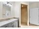 Primary bath featuring tiled shower stall and vanity with granite countertop and modern lighting at 2186 Coffee Pot Ne Blvd, St Petersburg, FL 33704