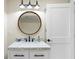 Bathroom featuring white marble vanity, modern lighting, and a round mirror at 2186 Coffee Pot Ne Blvd, St Petersburg, FL 33704