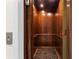 Classic wood-paneled elevator interior featuring a detailed carpet and functional control panel at 2186 Coffee Pot Ne Blvd, St Petersburg, FL 33704