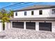 Exterior elevation featuring an attached garage with driveway pavers, dark garage doors and white brick at 2186 Coffee Pot Ne Blvd, St Petersburg, FL 33704