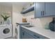 Well-organized laundry room with blue cabinets, a sink, modern washer and dryer, and stylish decor at 2186 Coffee Pot Ne Blvd, St Petersburg, FL 33704