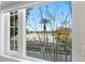 Picturesque view of a lake with a palm tree and waterfront homes framed by a multi-pane window at 2186 Coffee Pot Ne Blvd, St Petersburg, FL 33704