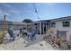 Backyard featuring a gravel area, blue chairs, fire pit, and a screened-in porch, creating an ideal outdoor living space at 2311 Wellesley, Bradenton, FL 34207