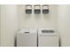 Bright laundry room with washer, dryer, and shelving at 2645 Sunray Venus Way, Ruskin, FL 33570