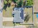 Aerial view of a well-maintained home with a spacious yard, solar panels and mature trees at 2653 Cover Ln, North Port, FL 34286