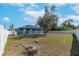 Expansive backyard with white fence, some mature trees, and blue home exterior at 2653 Cover Ln, North Port, FL 34286