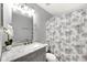 Well-lit bathroom featuring a marble vanity, flower patterned shower curtain, and neutral color palette at 2653 Cover Ln, North Port, FL 34286