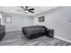 Cozy bedroom featuring stylish gray walls, modern ceiling fan, and sleek gray wood-look floors at 2653 Cover Ln, North Port, FL 34286