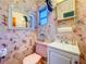 Unique powder room featuring patterned wallpaper, novelty decor, and classic pink toilet at 2907 W Euclid Ave, Tampa, FL 33629