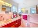 Retro pink bathroom with vintage tile, a coordinating toilet, and a vanity with storage at 2907 W Euclid Ave, Tampa, FL 33629